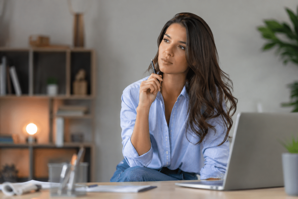 Femme s'interrogeant à son bureau sur le bon moment pour passer une certification