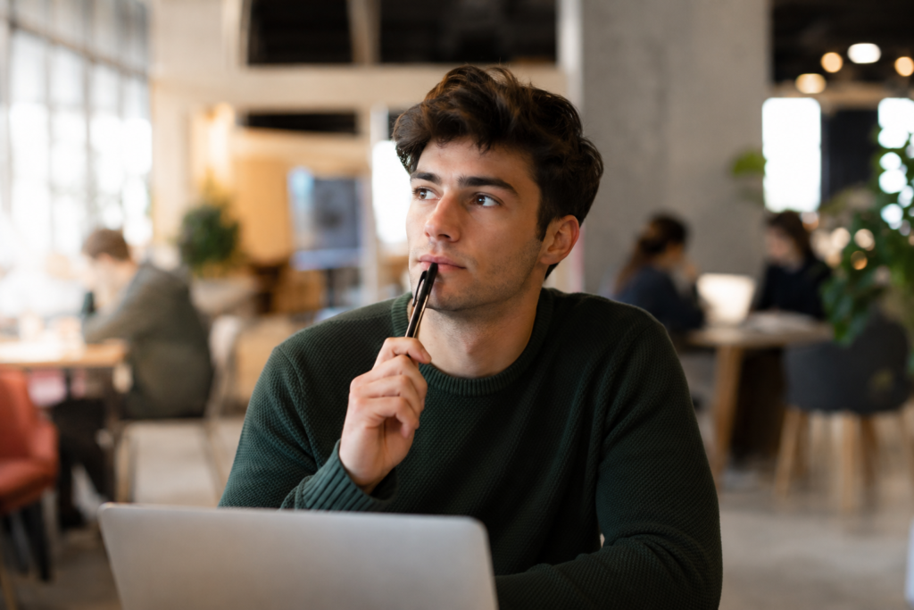 Homme réfléchissant devant son ordinateur portable, certification professionnelle face à l'expérience